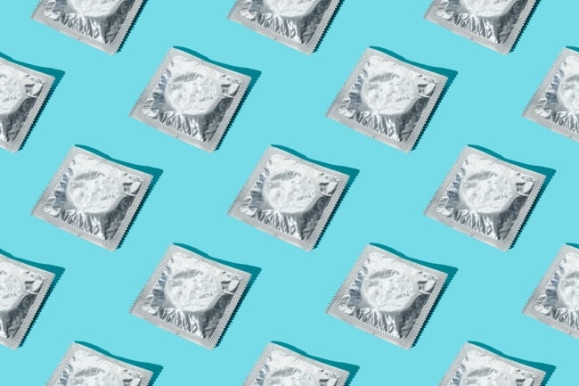 A pattern of silver condom wrappers on a blue background